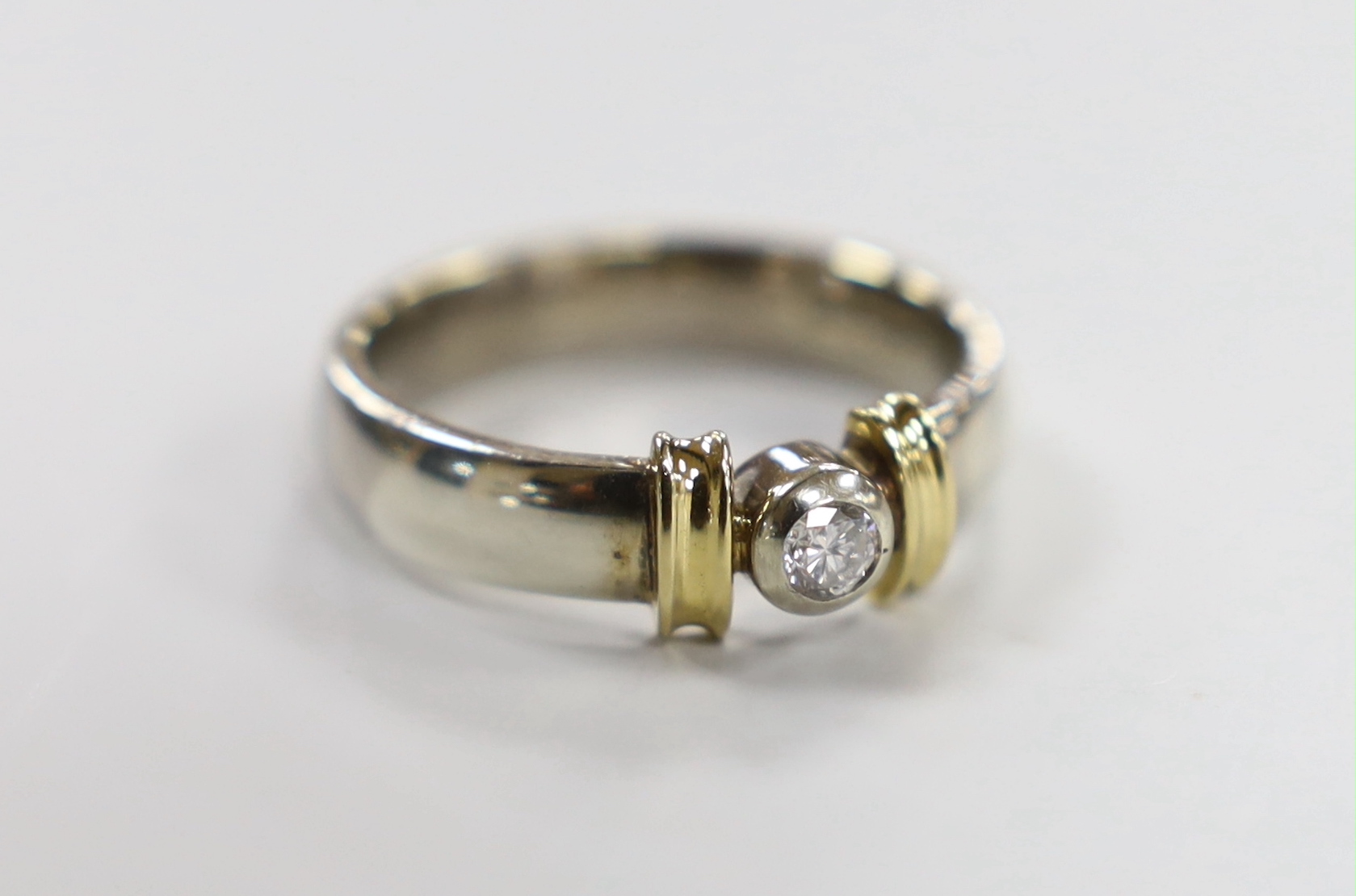 A modern two colour 9ct gold and single stone diamond set ring, size V/W, gross weight 9.1 grams.